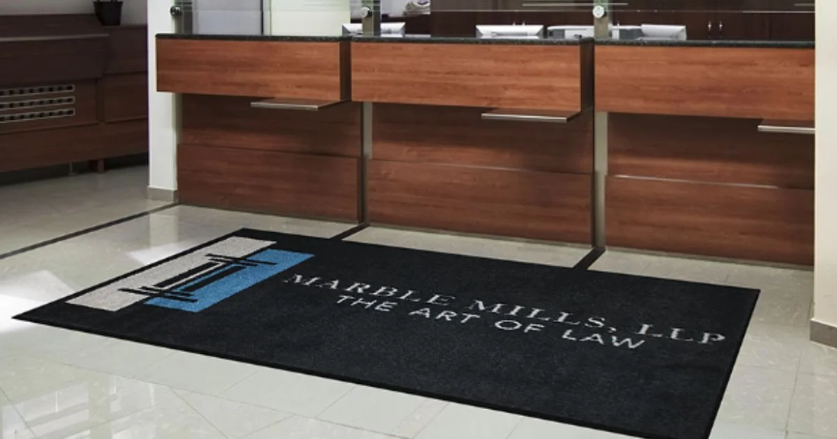 Professional law office reception area with a custom black logo mat reading "Marble Mills, LLP – The Art of Law"